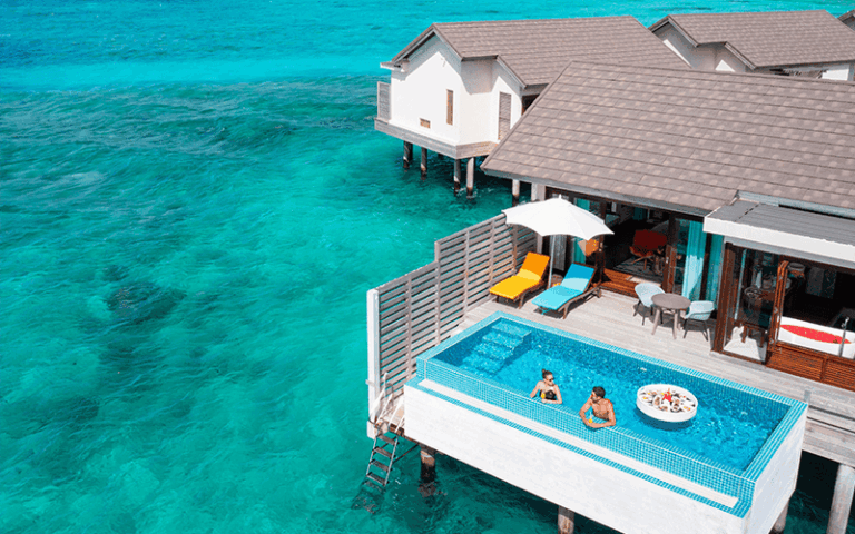 atmosphere kanifushi maldives sunset water villa with pool aerial floating breakfast lifestyle 01 09 2023 v2